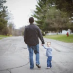 man-holding-his-inner-child-hand-while-walking