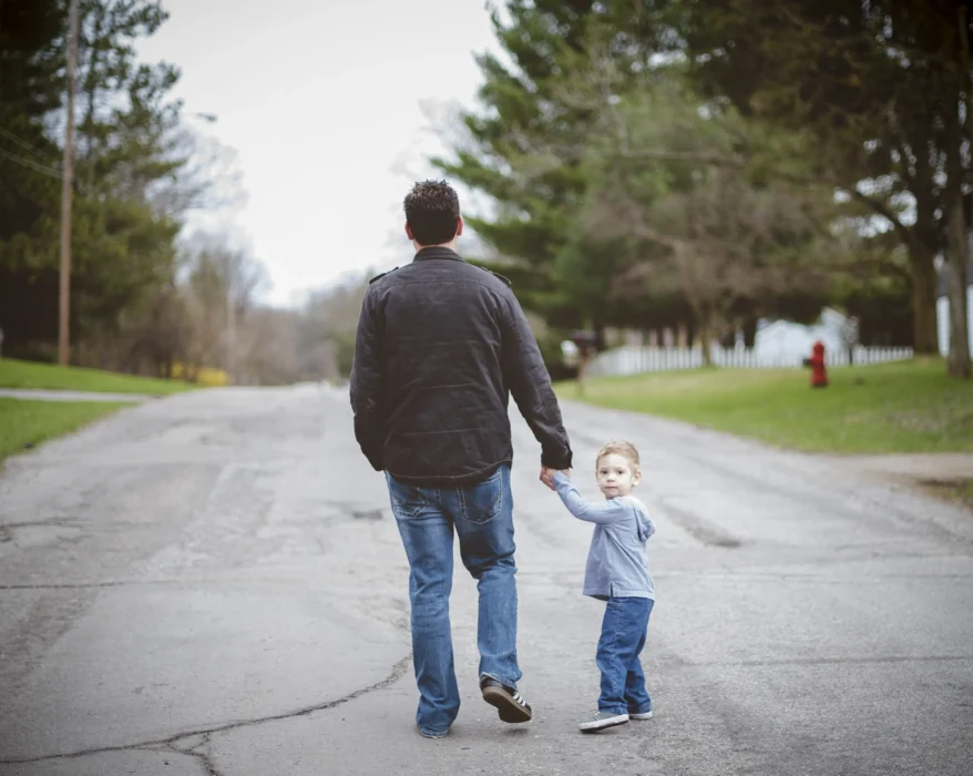 man-holding-his-inner-child-hand-while-walking