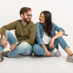 stylish-couple-sitting-on-floor-in-jeans