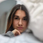 young-girl-looks-in-the-mirror-reflection